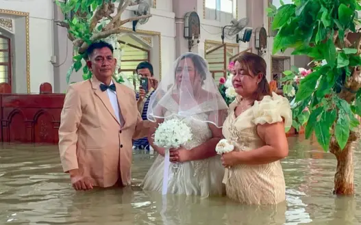 Couple holding their wedding inside flooded St. John the Baptist Parish in Hagonoy, Bulacan