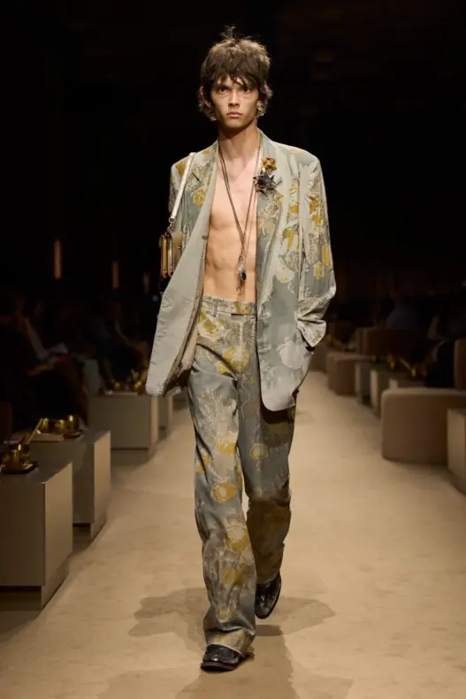 Model in an open floral jacquard suit on the Coach Spring 2027 runway celebrating the house’s 85th anniversary