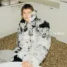 Leon Dame seated in an oversized curly shearling coat for Bottega Veneta Fall 2026