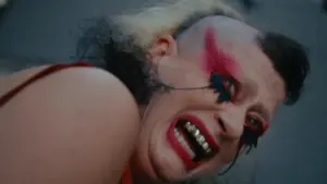 Peaches in the NOWNESS art film for “You’re Alright,” surrounded by surreal creature-drag imagery