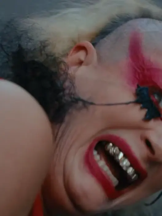 Peaches in the NOWNESS art film for “You’re Alright,” surrounded by surreal creature-drag imagery