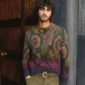 Pedro Pinto wearing a green, purple and magenta paisley Etro knit polo with olive corduroy trousers