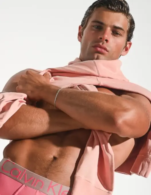 Isaiah Frederich posing with a pink shirt and Calvin Klein waistband in a photograph by Frank Louis