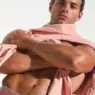 Isaiah Frederich posing with a pink shirt and Calvin Klein waistband in a photograph by Frank Louis