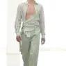 Male runway model wearing a pale green striped wrap-front shirt and matching relaxed trousers from SIEGENTHALER's Axis Mundi Spring/Summer 2027 collection.