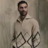 George Alsford wearing a brown shearling-collar jacket over dark tailored suiting for Brunello Cucinelli Winter 2026.