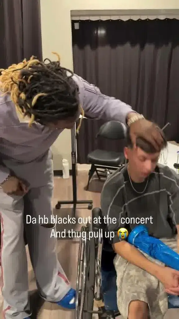 Young Thug lifting the concertgoer’s head backstage