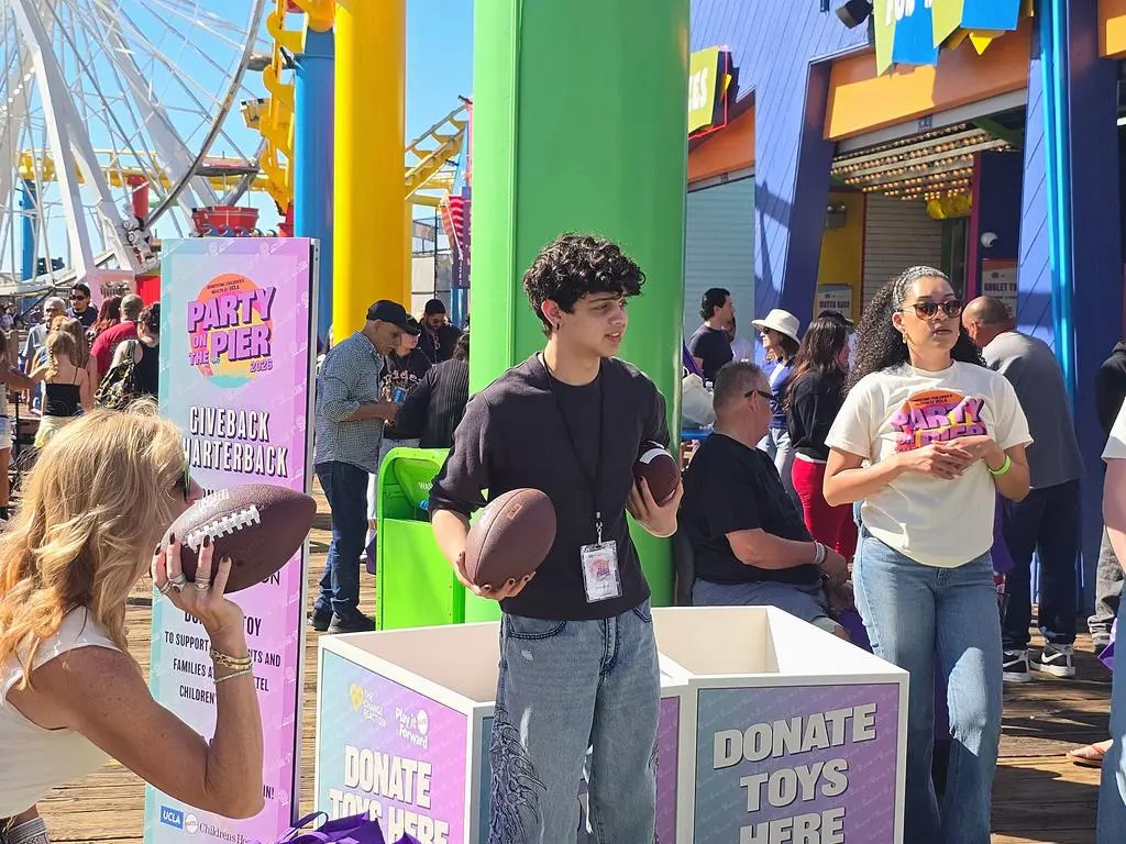 Isaac Ordonez and the football-and-toy-donation activity at Party on the Pier