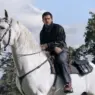 Kit Harington riding a white horse in a black fringed leather jacket for Kith Winter 2026