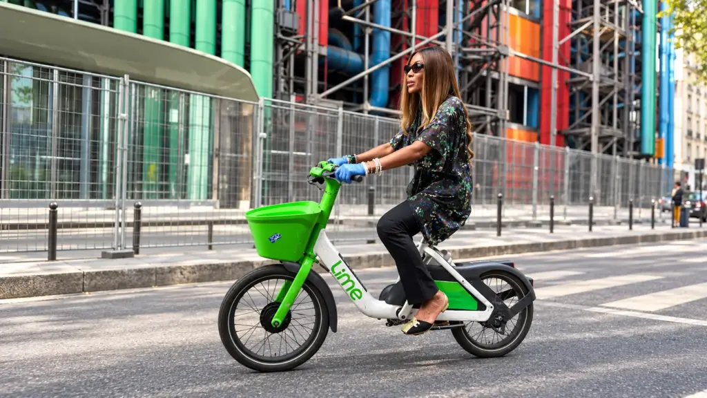 Naomi Campbell riding a Lime e-bike in Paris during Fashion Week