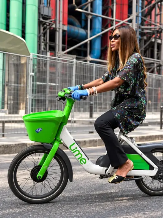 Naomi Campbell riding a Lime bike in Paris during Fashion Week