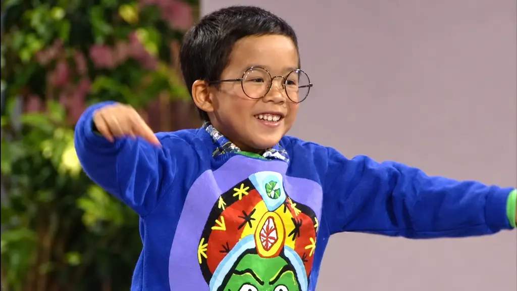 Young model in blue graphic sweatshirt and glasses showing the Pee-wee clothing collection