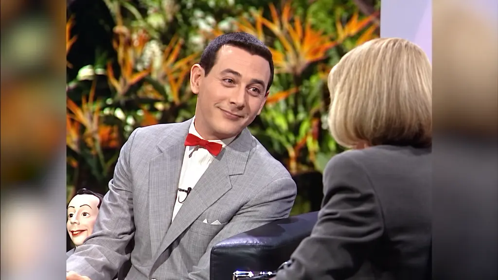 Pee-wee Herman and Joan Rivers talking on the set, with Pee-wee’s ventriloquist doll nearby