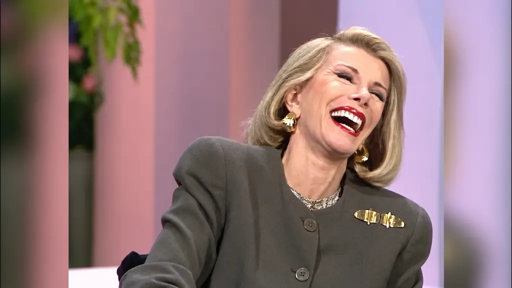 Joan Rivers throwing her head back in laughter during her interview with Pee-wee Herman
