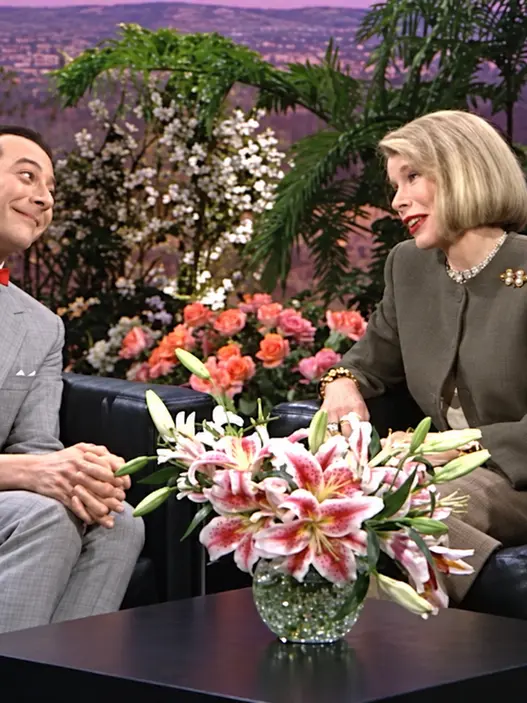 Pee-wee Herman and Joan Rivers smiling together during their 1989 television interview on The Joan Rivers Show