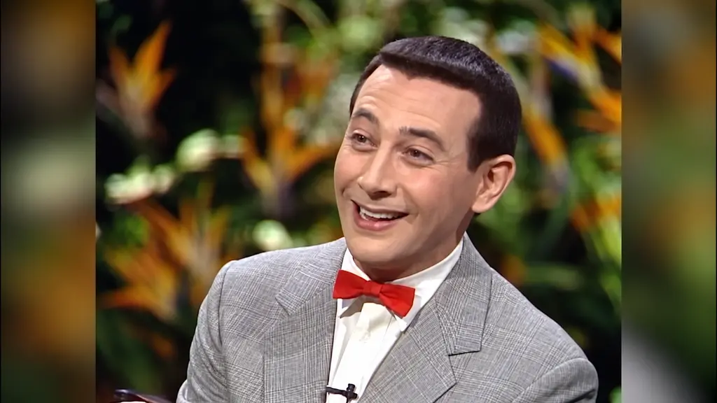 Pee-wee Herman smiling in gray suit and red bow tie on The Joan Rivers Show