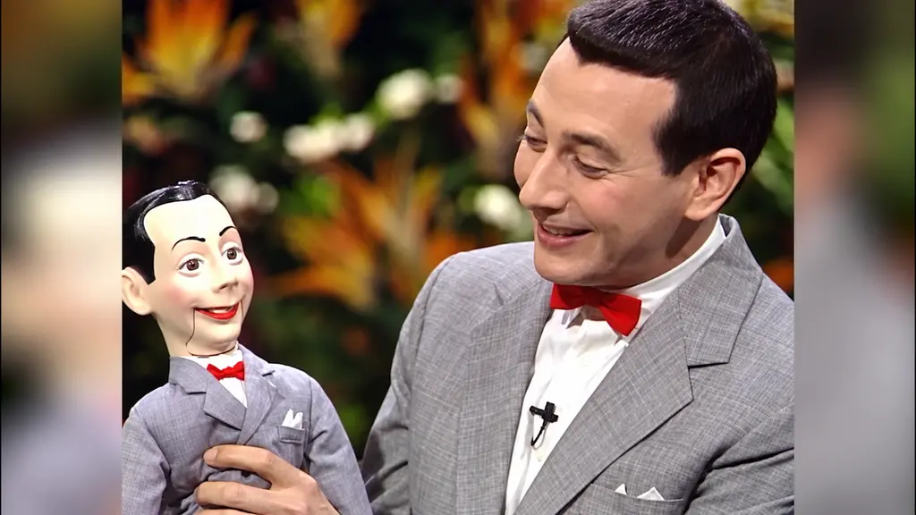 Pee-wee Herman smiling with a ventriloquist doll made in his likeness on The Joan Rivers Show