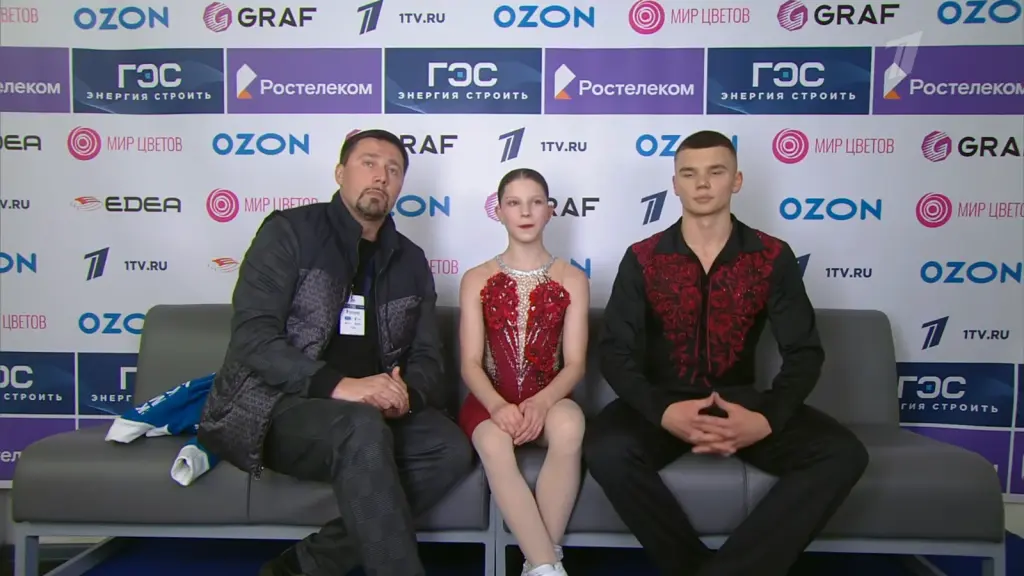 Alexander Samorukov seated with Darya Tretyakova and their coach