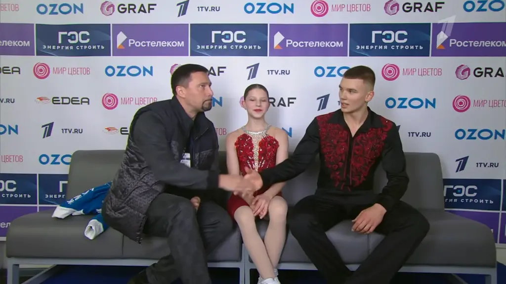Alexander Samorukov shaking hands with his coach beside Darya Tretyakova