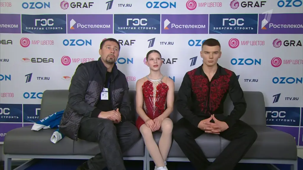 Alexander Samorukov seated with Darya Tretyakova and their coach