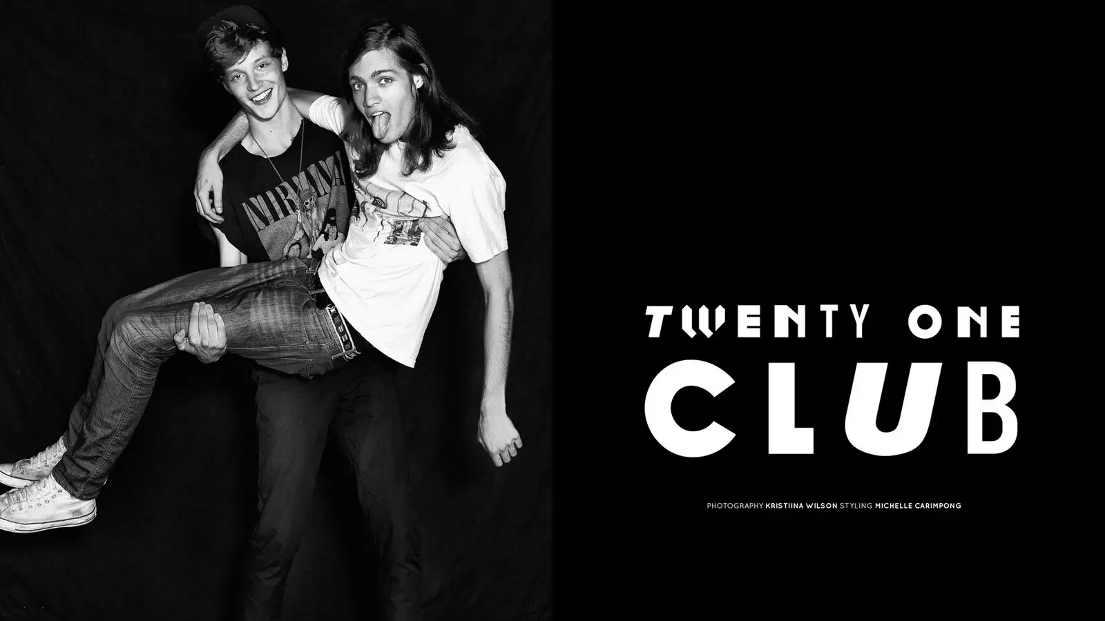 Two male models pose playfully against a black backdrop, with one carrying the other, beside large “Twenty One Club” lettering.