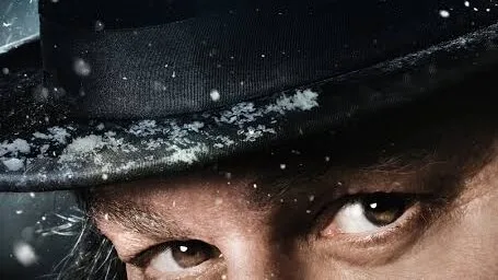 Promotional poster featuring Johnny Depp’s eyes beneath a hat, falling snow, and the red title “Ebenezer.”