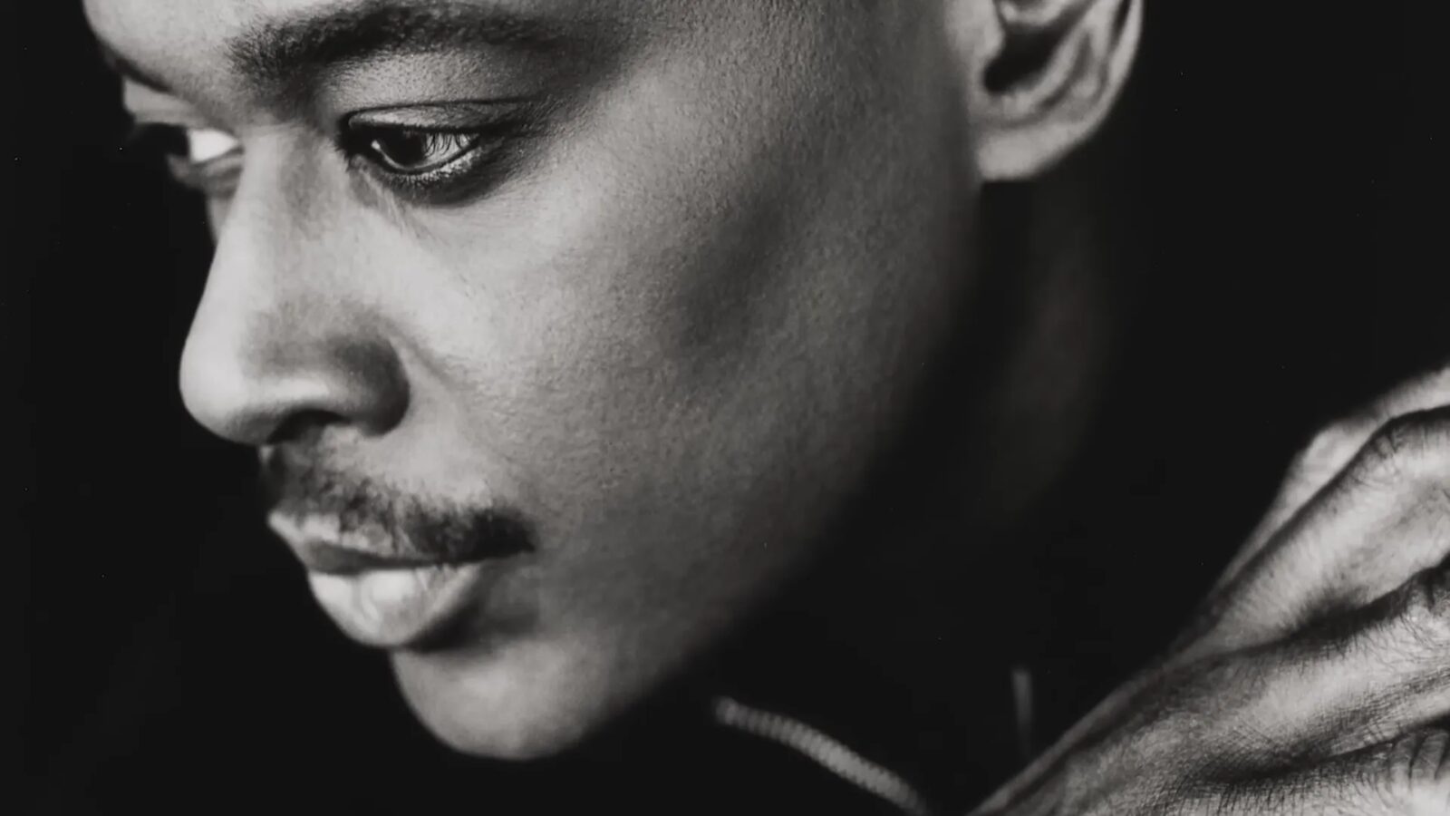 Black-and-white close-up portrait of Luther Vandross looking downward.