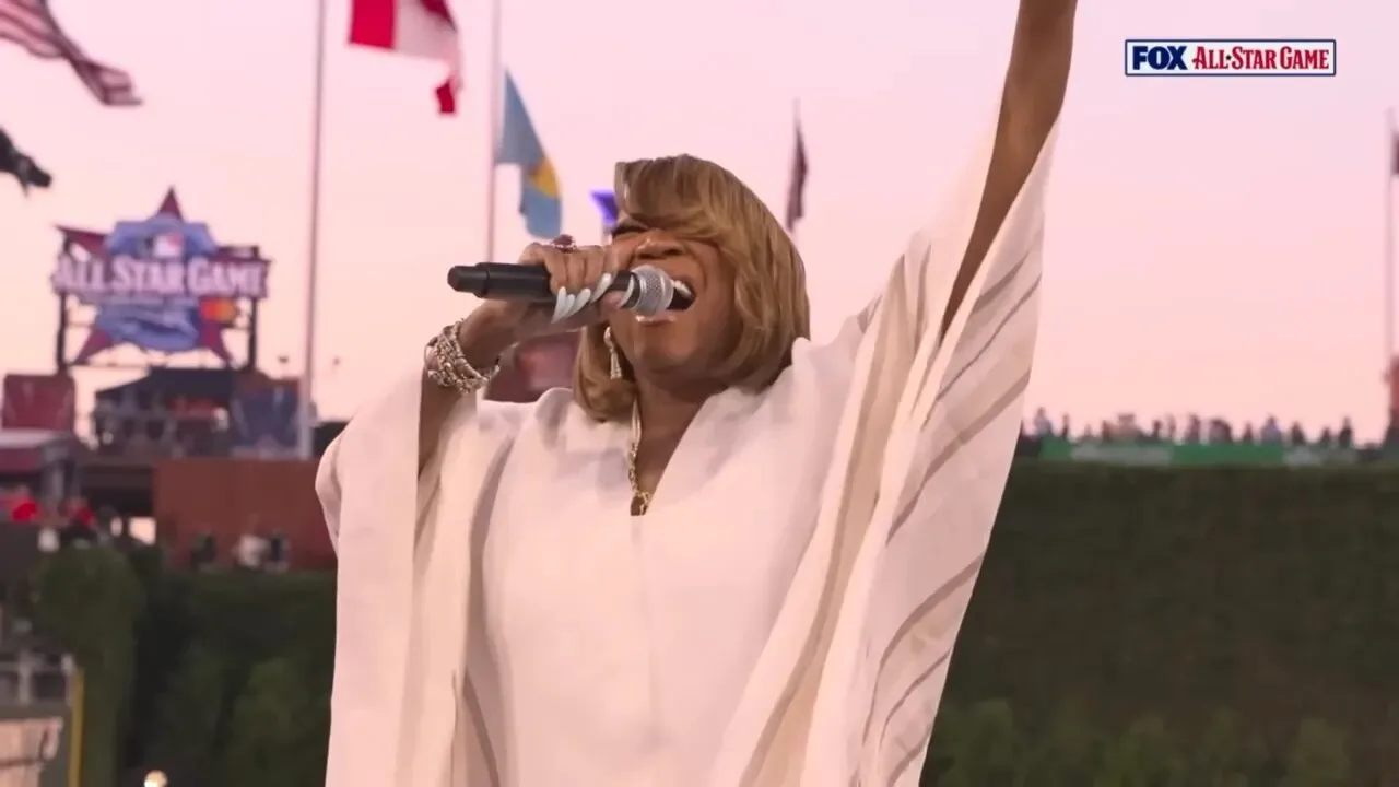 Patti LaBelle sings into a microphone with one arm raised during her national anthem performance before the 2026 MLB All-Star Game.