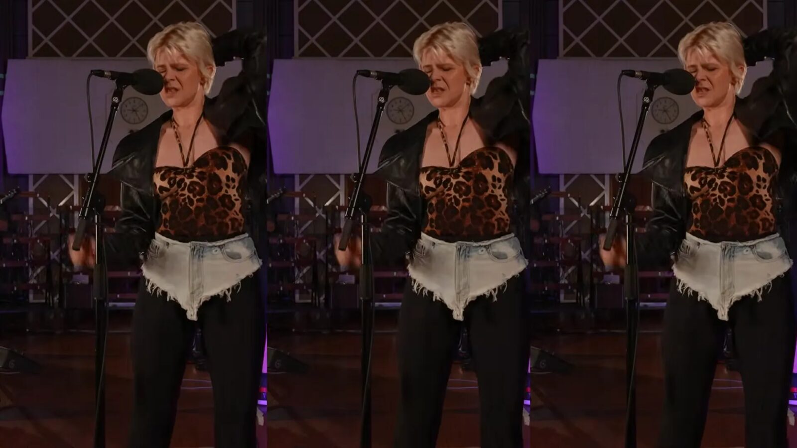 Robyn sings into a microphone during a live session, wearing a leopard-print top and black jacket.