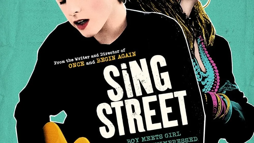 Stylized poster art shows a young man holding an acoustic guitar in front of a young woman wearing sunglasses, with the title "Sing Street" prominently displayed.