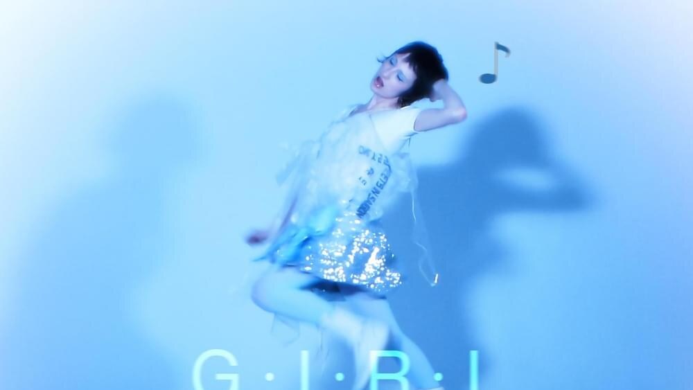 Blue-tinted artwork shows a woman in a white top and reflective silver skirt posing above her mirrored reflection, with musical-note graphics and the text “G.I.R.L.,” “8485,” and “danny brown.”