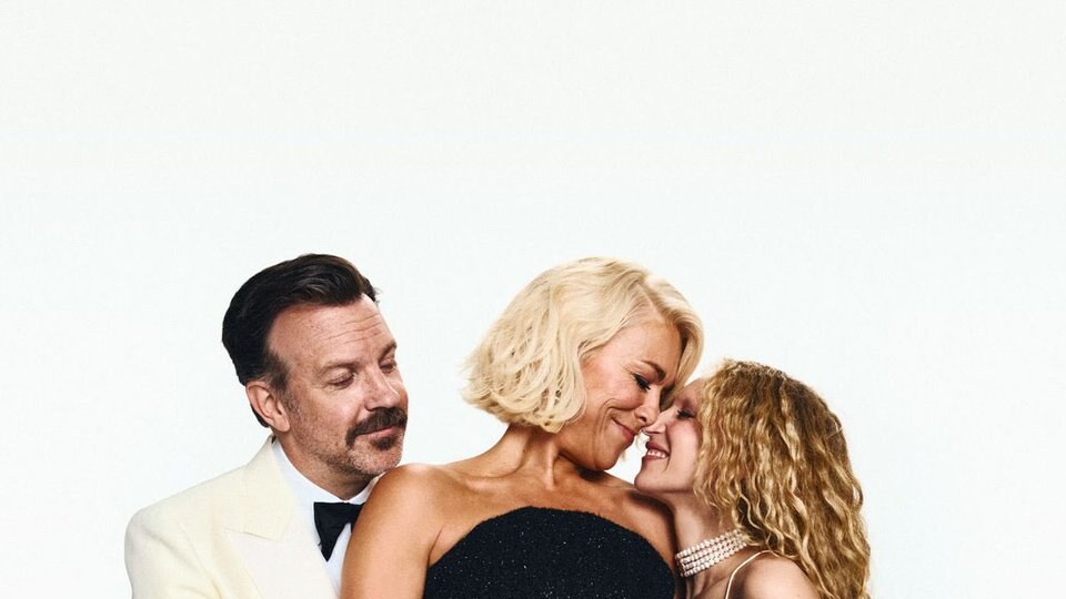 Jason Sudeikis, Hannah Waddingham and Juno Temple pose closely together, smiling in formal attire against a light background.