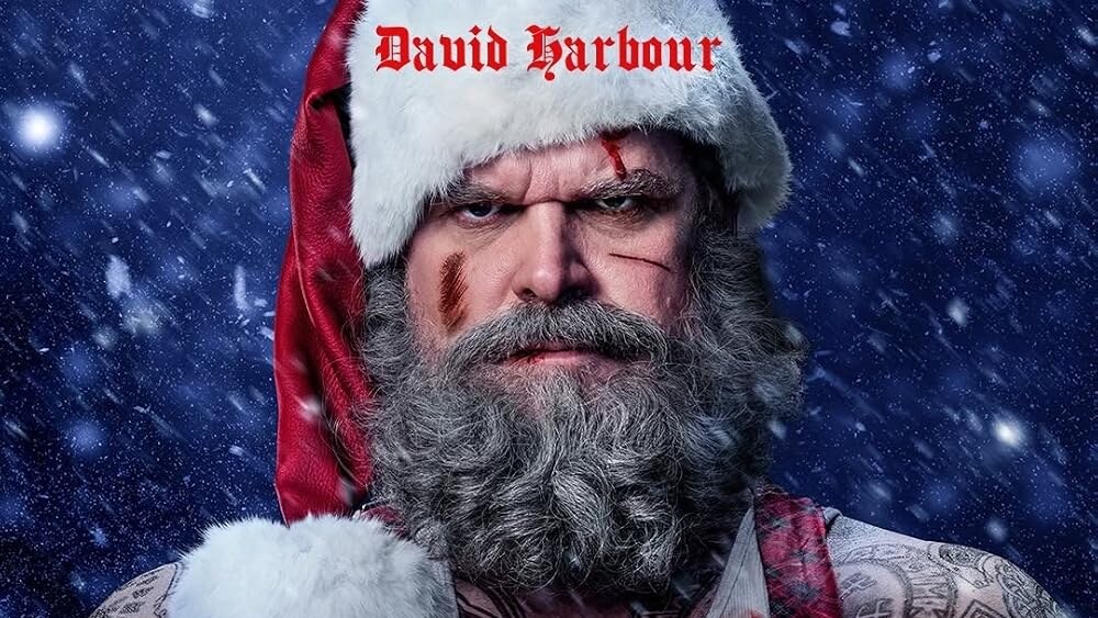 David Harbour appears as a tattooed, bruised Santa Claus with crossed arms against a snowy blue background, with Violent Night 2 title text below.