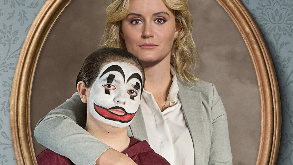 Taylor Schilling embraces Bryn Vale, who wears theatrical face paint, on the poster for Family.