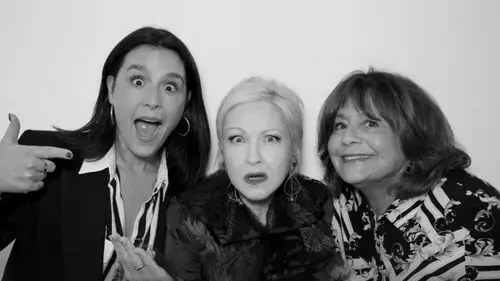 Cyndi Lauper poses between Jessie Ware and Lennie Ware, with all three making playful expressions above the “Table Manners” podcast title.